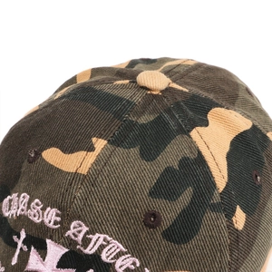 Détail de la broderie croix rose sur une casquette de baseball camouflage rétro