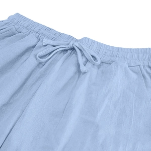 Detail of light blue linen trousers showing elastic waist, drawstring, and fabric texture