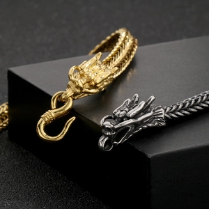 Detailed close-up of dragon head bracelets in gold and silver steel finishes