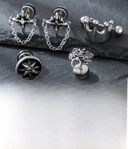 Macro detail of silver titanium steel crown and star chain earrings with zircon studs