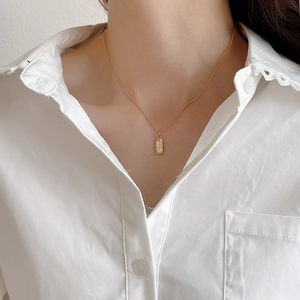 Detail view of a 925 sterling silver golden necklace with textured irregular pendant