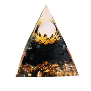 Orgone crystal pyramid with gold foil, black stones and white sphere lotus base