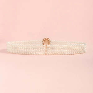 Detail of elegant four-row pearl waist chain with a polished gold-tone oval buckle