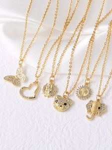 Detailed view of assorted gold-plated necklaces with butterfly and bear pendants on satin