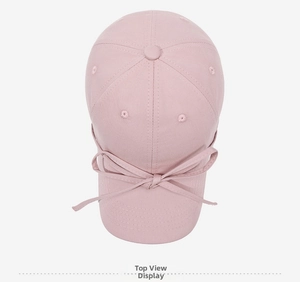 Top view of pink cotton baseball cap featuring a decorative ribbon bow on the brim