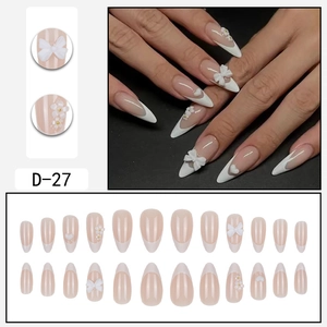 Almond French false nails with 3D white bows and pearl heart accents in a full set
