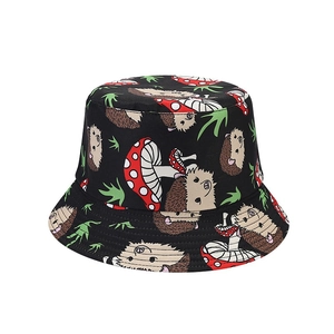 Reversible bucket hat featuring colorful cartoon hedgehog and mushroom patterns on canvas