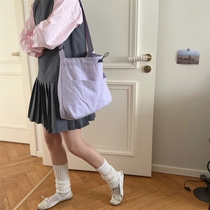 Grande borsa tote in nylon color lavanda con coulisse laterale mostrata su modella