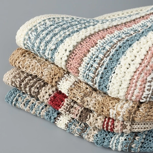 Detail of stacked hollow knit bucket hats showing various colors and crochet textures