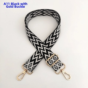 Macro detail of black and white chevron wide bag strap with gold lobster clasps