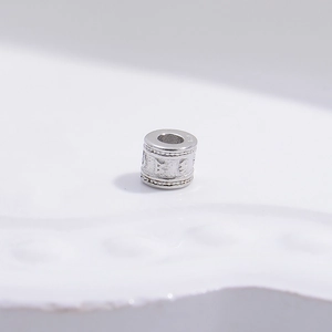 Detailed macro view of S925 sterling silver mantra barrel bead with relief patterns
