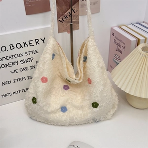 Detailed shot of white lace tote bag with floral embroidery and frayed fringe edges