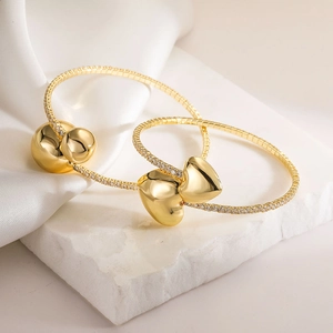 Elegant gold-plated heart and bead jewelry set with pavé cubic zirconia on marble base