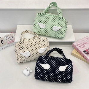 Polka dot travel toiletry bags with plush wings in mint green, beige, and black