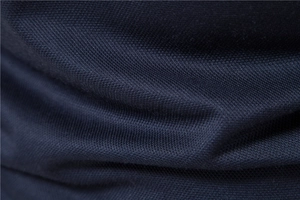 Macro shot of dark blue piqué knit cotton fabric texture for breathable polo shirt