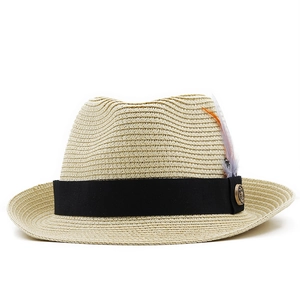 Detail of straw hat weave with black ribbon, colorful feathers and metal badge