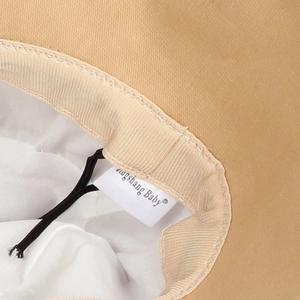 Détail de l'intérieur d'un chapeau soleil bébé avec doublure blanche et cordon réglable