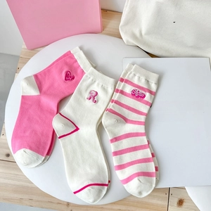 Close-up of pink and white striped cotton socks with delicate heart embroidery details