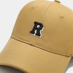 Close-up of premium khaki baseball cap featuring 3D embroidered R logo and twill texture