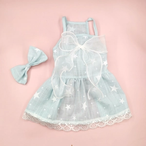 Detail of light blue pet floral dress with star patterns and matching bow accessory