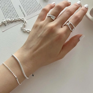 Detail of 925 sterling silver heavy snake chain bracelet and twisted ring set on model