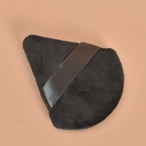Dettaglio macro di un piumino da cipria triangolare nero con cinturino in raso liscio