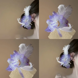 Macro detail of the elegant lavender fabric flower hair clip with soft white feathers