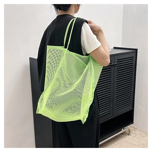 Dettaglio della borsa tote in rete verde neon che mostra la trama in nylon traslucido