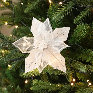 Sparkling white mesh Christmas flower ornament with glitter on a festive tree branch