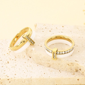 Detailed view of gold stainless steel and white ceramic ring with cubic zirconia stones