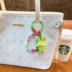 Colorful acrylic rabbit charm keychain with letter beads and gradient pearls on white bag
