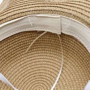 Close-up of woven straw hat interior featuring an adjustable drawstring and sweatband