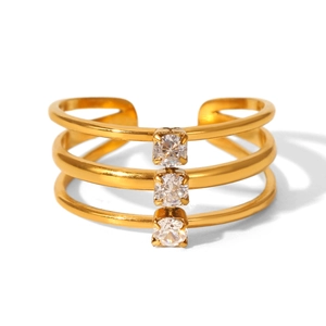Makro-Detail des dreilagigen vergoldeten Rings mit drei weißen Zirkonia-Steinfassungen