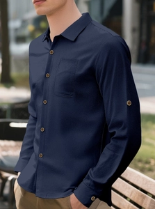 Detail of navy blue linen shirt featuring lapel collar, pocket and vintage buttons