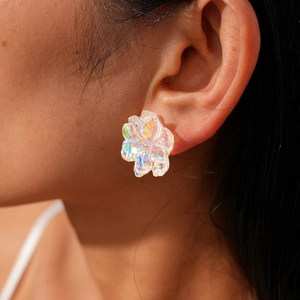 Close-up of a model wearing an iridescent flower stud earring with resin petals