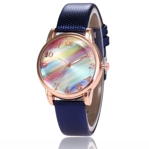 Detail of rose gold case with rainbow sunburst dial and blue textured leather strap