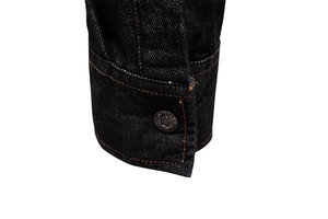 Close-up of denim shirt cuff with orange contrast stitching and fashion metal buttons