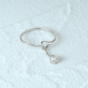 Macro detail of S925 sterling silver ring with dangling heart charm and zircon stone