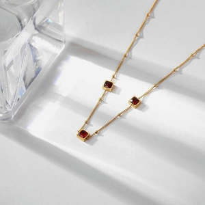 Titanium steel gold necklace featuring three square red gemstones in a minimalist design