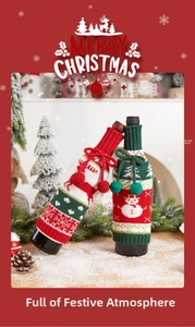Detail of Christmas knitted wine bottle cover with reindeer patterns and pom-poms
