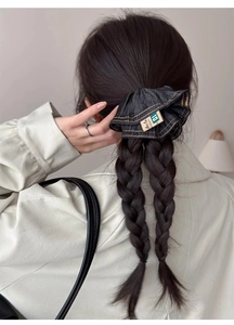 Detail of dark blue denim scrunchie with yellow stitching on a braided hairstyle