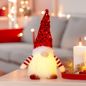 Close-up of a glowing Christmas gnome with red sequin hat and warm light detail