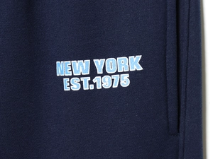 Close-up of New York Est.1975 screen print on navy blue knit tracksuit fabric