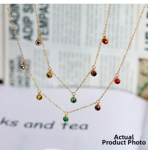 Detail of 18K gold plated necklaces with vibrant round colorful gemstone pendants