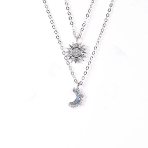 Detail of sun and moon layered necklaces with inlaid blue zircons and silver chains