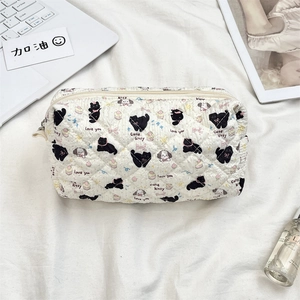 Detailed top view of a white quilted makeup bag with cute cartoon cat and dog patterns