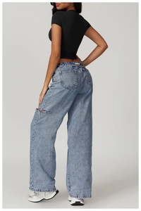Detailed back view of light blue washed wide-leg jeans with a unique thigh cutout detail