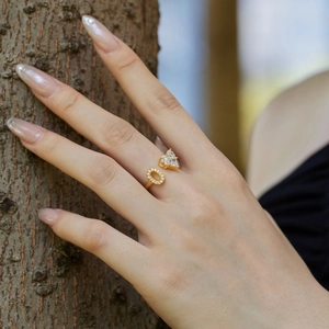Close-up of adjustable gold S925 silver ring with white heart zircon on a model hand