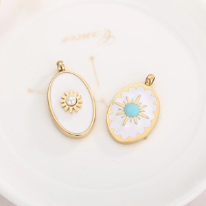 Detailed macro view of gold oval charms with pearl and turquoise sunburst details