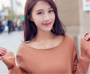 Collier en argent avec pendentif mot Angel porté par un mannequin sur fond de ville